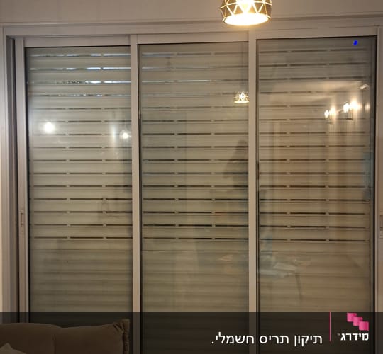 סלון עם תריסים סגורים ושולחן עם חפצים שונים